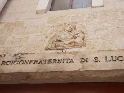 Dei due portali in legno il primo, pi� piccolo, � sormontato da un architrave su cui si innesta una formella scolpita con la Madonna col Bambino